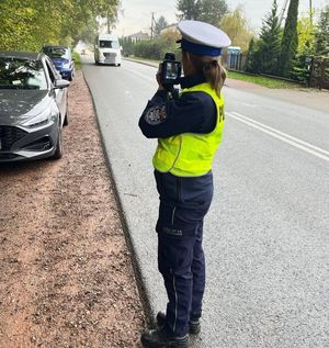policjantka sprawdza prędkość kierowców przy pomocy miernika prędkości