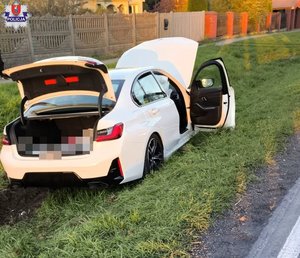 białe BMW po zderzeniu z ciężarówką na drodze