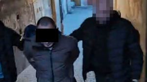 policjanci prowadzą zatrzymanego mężczyznę