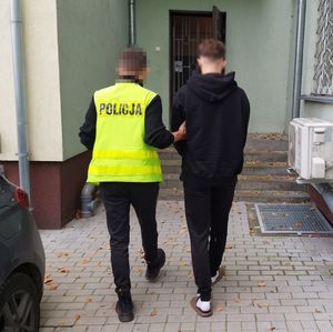 policjant prowadzi zatrzymanego