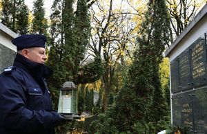 komendant Gil ze zniczem przy pomniku