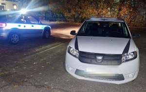 samochód na parkingu, w tle policyjny radiowóz