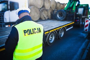 stojący na drodze policjant i naczepa - najazd dołączony do samochodu ciężarowego