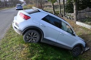 Samochód stojący przodem w rowie, za nim w tle widoczny jest radiowóz