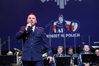 Policjant w mundurze śpiewa podczas gali.