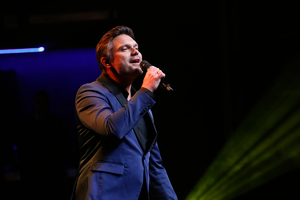 Wokalista Marcin Jajkiewicz śpiewa podczas gali.