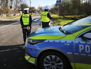 policjanci drogówki podczas mierzenia prędkości pojazdów na drodze