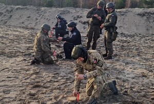 policjanci podczas ćwiczeń. Klęczą na poligonie