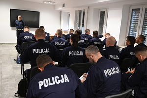 policjanci siedzą na krzesłach i rozwiązują test