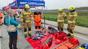 strażacy i ratownik medyczny rozmawiają z kobietą