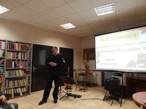 Umundurowany policjant prowadzi prelekcje w budynku biblioteki