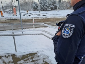 Funkcjonariusze policji  patrolują i sprawdzają teren linii kolejowej