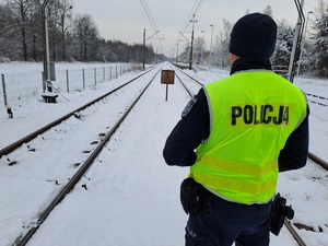 Funkcjonariusze policji  patrolują i sprawdzają teren linii kolejowej