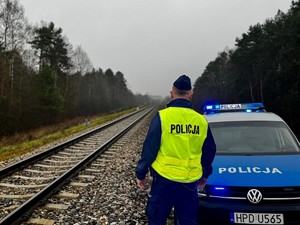 Funkcjonariusze policji  patrolują i sprawdzają teren linii kolejowej