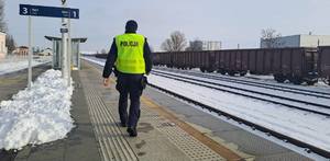 Funkcjonariusze policji  patrolują i sprawdzają teren linii kolejowej