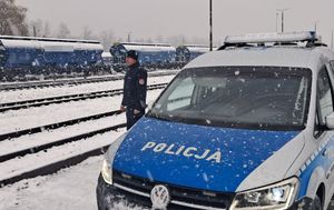 Funkcjonariusze policji  patrolują i sprawdzają teren linii kolejowej