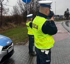 policjanci z miernikiem prędkości przy drodze