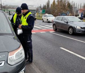 policjanci z miernikiem prędkości przy drodze