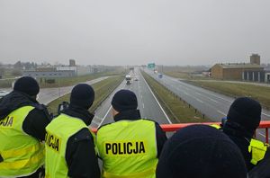 Na zewnątrz przy drodze trwa kurs specjalistyczny z obsługi ręcznych mierników prędkości