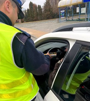 policjant sprawdza trzeźwość kierowcy pojazdu