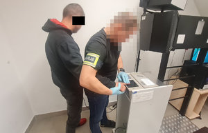 policjant pobiera odciski linii papilarnych od zatrzymanego