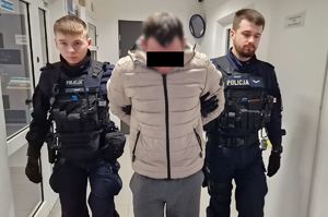 policjanci doprowadzają zatrzymanego mężczyznę