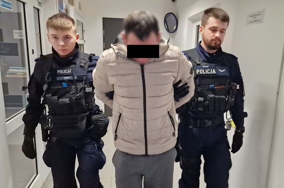 policjanci doprowadzają zatrzymanego mężczyznę