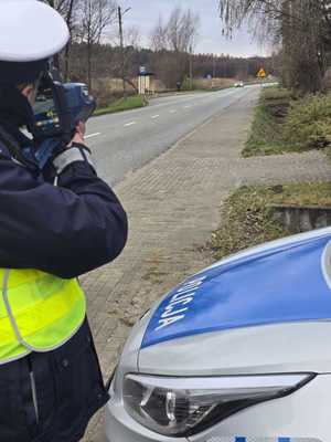 policjant podczas pomiaru prędkości pojazdu