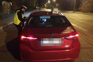 Policjant kontroluje taksówkarza.