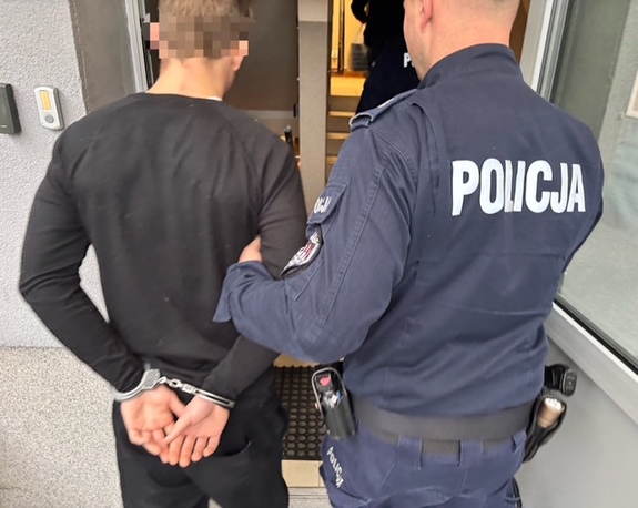 policjant i doprowadzany zatrzymany