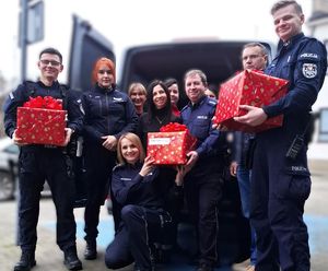 policjanci i policjantki z paczkami pod budynkiem komendy