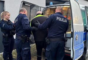 policjanci prowadzą zatrzymanego 36-latka do radiowozu