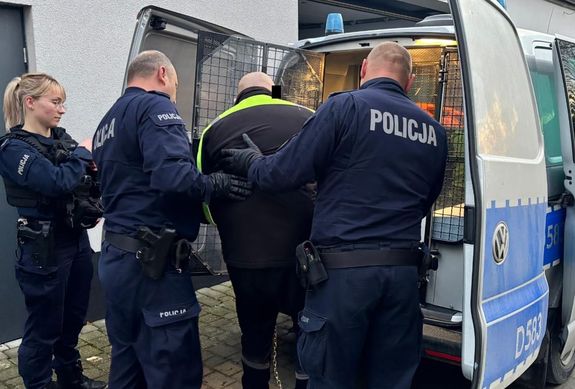 policjanci prowadzą zatrzymanego 36-latka do radiowozu