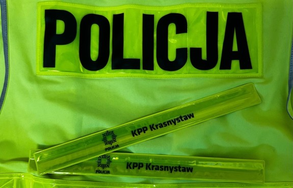 opaski odblaskowe leżące na kamizelce odblaskowej z napisem Policja