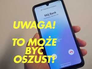 Telefon komórkowy trzymany w dłoni z napisem Uwaga! To może być oszust!