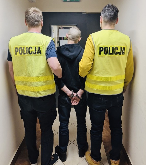 policjanci prowadzą zatrzymanego mężcyznę