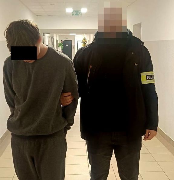 policjant kryminalny prowadzi zatrzymanego 19-latka
