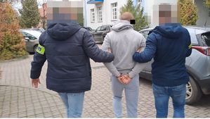 policjanci doprowadzają zatrzymanego