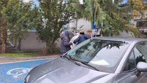 policjanci doprowadzają zatrzymanego