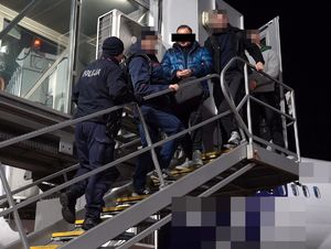 policjanci wyprowadzają z samolotu poszukiwanego