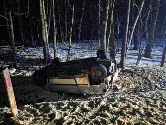 przewrócony na dach pojazd osobowy przy drzewach