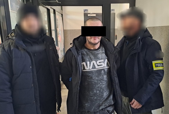 policjanci kryminalni prowadzą zatrzymanego mężczyznę