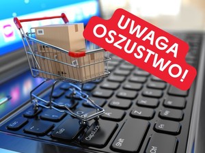 grafika internetowa. napis Uwaga oszustwo, klawiatura laptopa i koszyk zakupowy