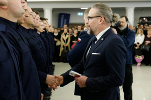 Komendant Wojewódzki Policji w Lublinie wraz z Pierwszym Wicewojewodą Lubelskim wręczają legitymacje nowym policjantom.