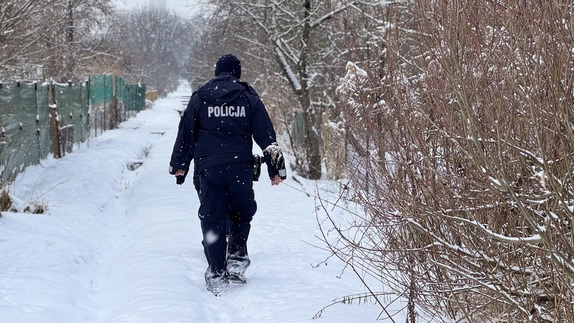 Policjant idzie po ośnieżonej ścieżce