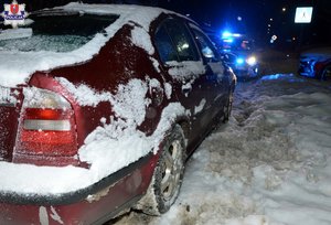 zaparkowana na poboczu drogi w śniegu skoda, w tle policyjny radiowóz