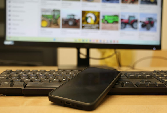 Zdjęcie klawiatury, telefonu i ekranu komputera z rozmazanym ekranem