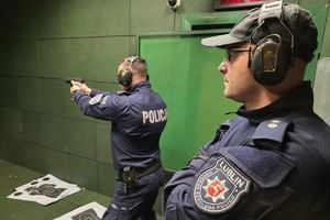 policjant celuje bronią w kierunku kulochwytu