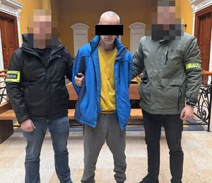 zatrzymany mężczyzna, obok policjanci