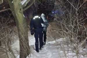 policjant prowadzi mężczyznę po śniegu